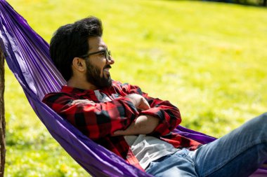 Hamaktaki adam rahat ve memnun görünüyor.