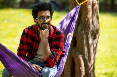 Genç Hindu adam parkta rahat ve mutlu hissediyor.