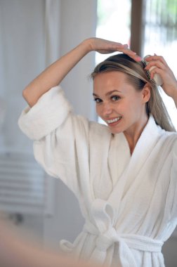 Saç yapıyorum. Sarışın genç kadın saç yapıyor.