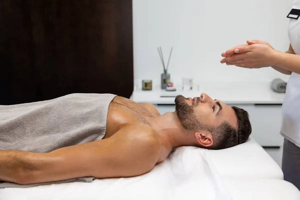 In a massage salon. Young man having relaxing procedures in a massage salon