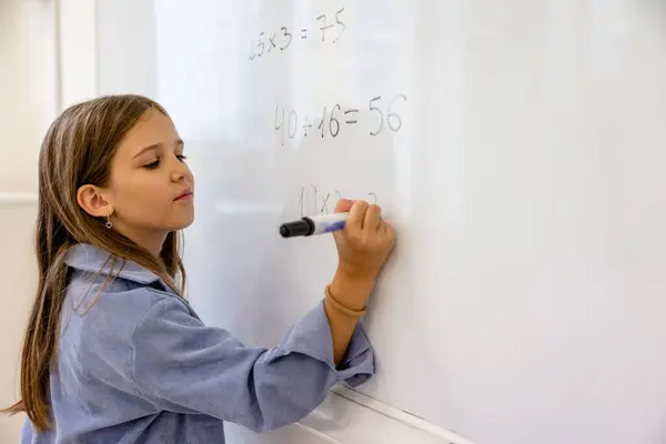 在学校白板上数数数学方程的小女孩 — 图库照片