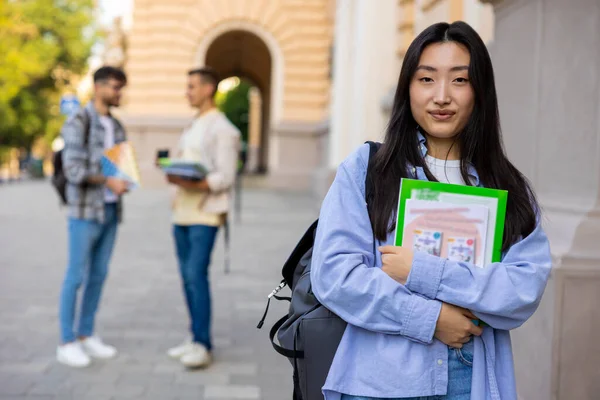 在大学大楼里 手里拿着书的亚洲女大学生 — 图库照片