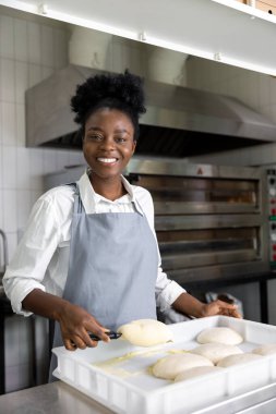 Pizzacı Afrikalı Amerikalı kadın pizza pişirmeye hazırlanıyor.