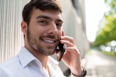 Telefon var. Elinde telefon olan zarif genç bir adam.