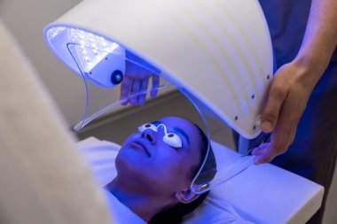 Fototerapi. Fototerapi seansı sırasında bir hastayla çalışan bir tıp uzmanı.