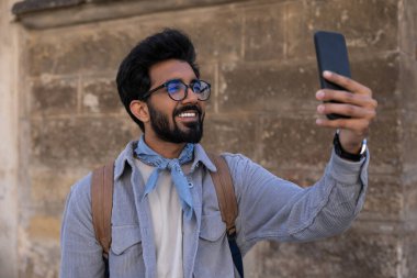 Gezmek için. Telefonda resim yapan gülümseyen genç adam.