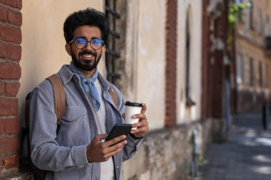 Telefon konuşması. Elinde telefonla gülümseyen siyah saçlı bir adam.
