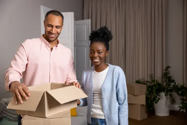 快乐的男女们搬到一幢新房子里 手里拿着装有财物的纸板箱 — 图库照片