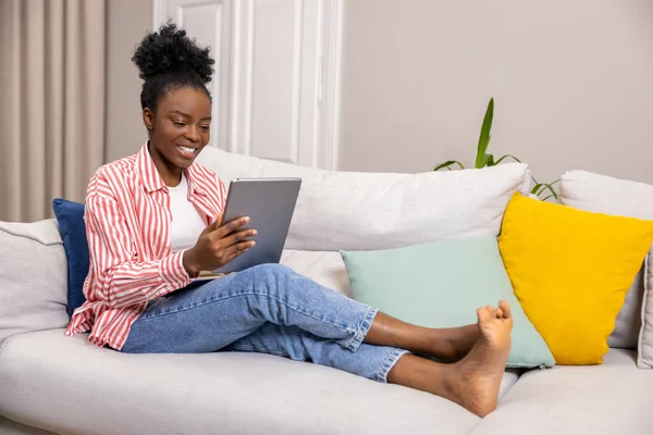 吸引人的黑人妇女在家里用数码平板电脑上网工作 — 图库照片