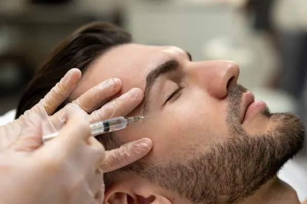メソセラピー 美容室でメソセラピーのセッションをしているダーク髪のひげ男 — ストック写真