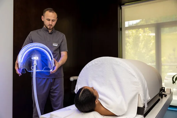 Phototherapy. Medical specialist working with a patient during the session of phototherapy