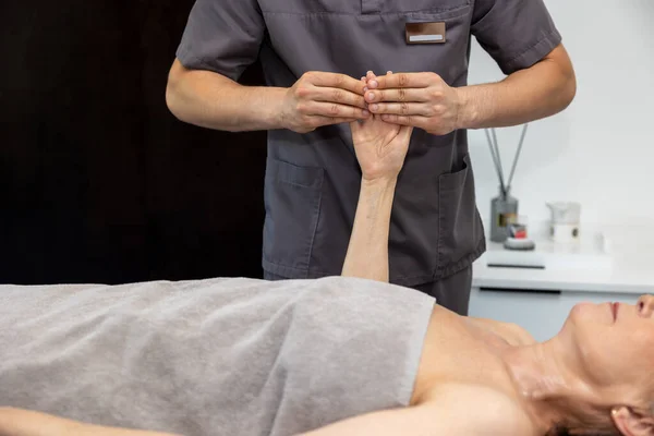 Hand massage. Male massage therapist doing hand massage to a female client
