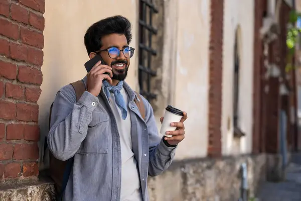 Telefon konuşması. Gülümseyen siyah saçlı adam telefonda konuşuyor.