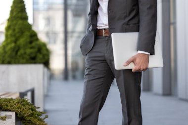 Elinde dizüstü bilgisayarla yürüyen zarif bir adama yaklaş.