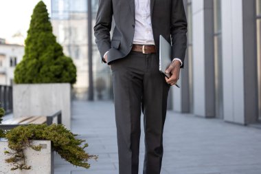 Elinde dizüstü bilgisayarla yürüyen zarif bir adama yaklaş.