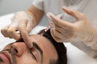 Mezoterapi. Kozmetik uzmanı erkeklerin yüzüne mesoterapi yapıyor.