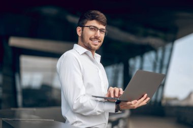 Müdürüm. Dizüstü bilgisayarı olan genç bir erkek yönetici memnun görünüyor.