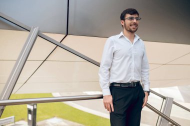 İş adamı. Memnun genç adam kendinden emin ve gülümsüyor.