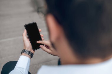 İletişim. Elinde telefon olan bir adam mesaj yazıyor.