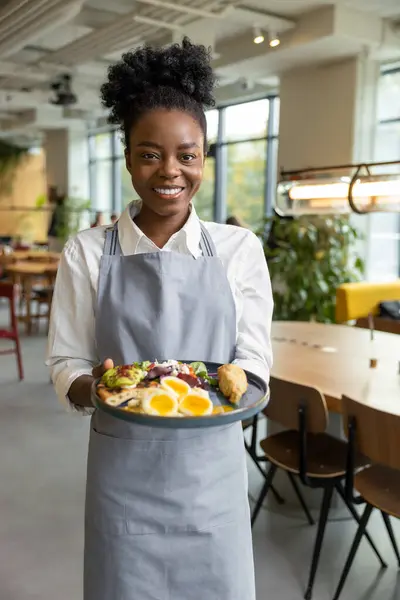 Önlüklü gülümseyen Afro-Amerikan garson.