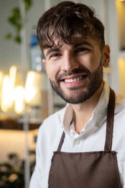 Gülümseyen genç pizzacı, kendini iyi hissediyor.