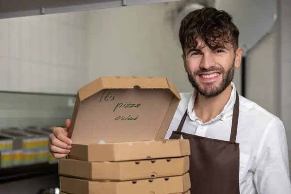 Male service man with many pizza boxes in pizzeria
