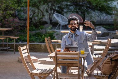 Öğle yemeği vakti. Hindu genç adam pizzacıda öğle yemeği yiyor.