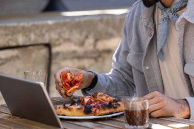 Pizza zamanı. Bir kafede pizza yiyen bir adam.