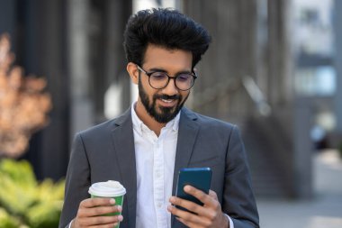 Genç işadamı dışarıda kahve içiyor ve iyi hissediyor.