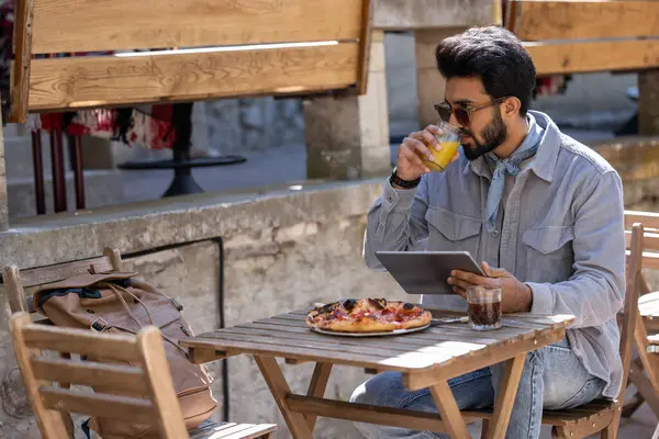 Öğle yemeği vakti. Hindu genç adam pizzacıda öğle yemeği yiyor.