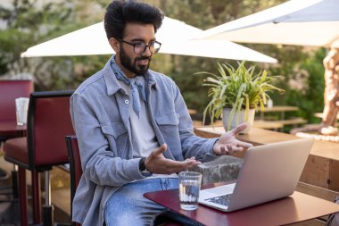 Görüntülü arama. Genç sakallı Hintli adam bir video görüşmesi yapıyor.