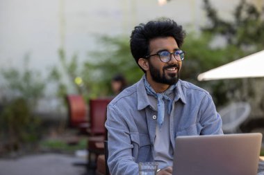 Dijital göçebe. Hindu adam bir kafede çalışıyor ve olaya dahil olmak istiyor.