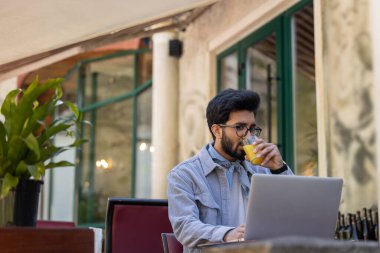 Dijital göçebe. Hindu adam bir kafede çalışıyor ve olaya dahil olmak istiyor.