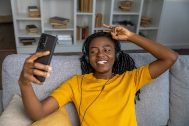 Sarı tişörtlü sevimli, gülümseyen genç bayan mutlu görünüyor.