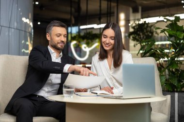 Meslektaşlar. İki meslektaş proje üzerinde birlikte çalışıyor ve ilgili görünüyor.