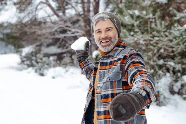 Feeling excited. Man in checkered jacket feeling good while spending time in a winter forest