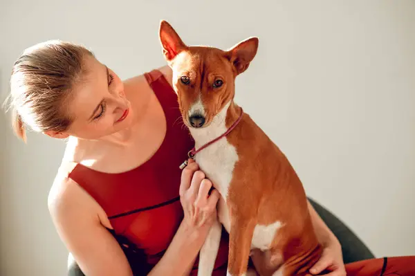 Sporty attractive woman holding dog in fitness class