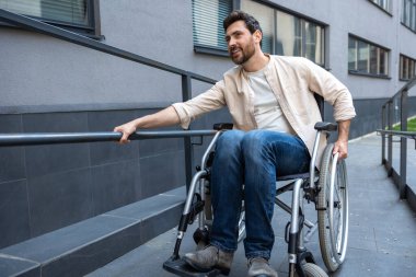 Keyfin yerinde. Tekerlekli sandalyedeki engelli adam pozitif görünüyor ve gülümsüyor.