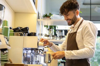 Kahve yapan sakallı bir adam. Kafede insanlar için kahve yapıyor.