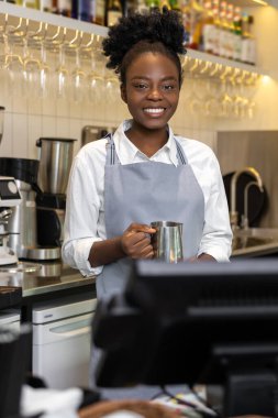 Neşeli kadın barmen barmen kahve tezgahında müşteriye kahve hazırlıyor.