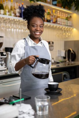 Kahveci kadın, kahve demliğinde cam çaydanlıktan aromalı kahve dolduruyor alternatif yöntemler üretiyor.