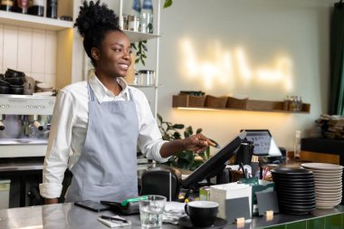 Kadın garson barmen tezgahta dijital kasaya basmadan önce faturayı kontrol ediyor.