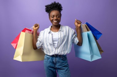 Alışverişten sonra. Hediye çantalarıyla gülümseyen esmer kız heyecanlı görünüyor.