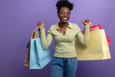 Alışverişten sonra. Hediye çantalarıyla gülümseyen esmer kız heyecanlı görünüyor.