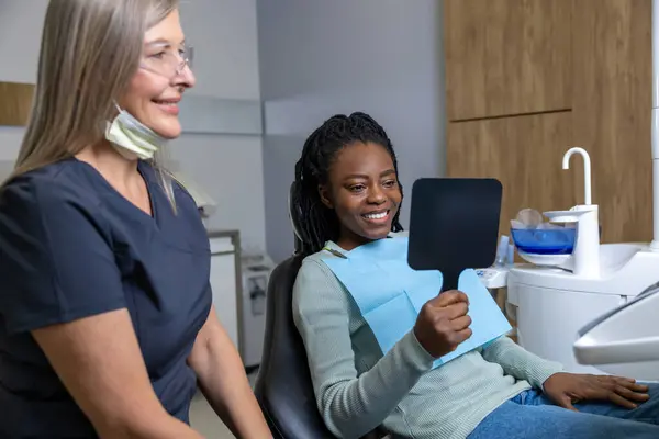 Klinikte Diş Tedavisinden Sonra Aynaya Bakan Mutlu Çok Kültürlü Kadın — Stok fotoğraf