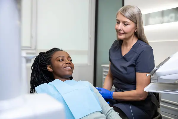在牙科诊所检查工具的女牙医在诊所接受牙科治疗 — 图库照片
