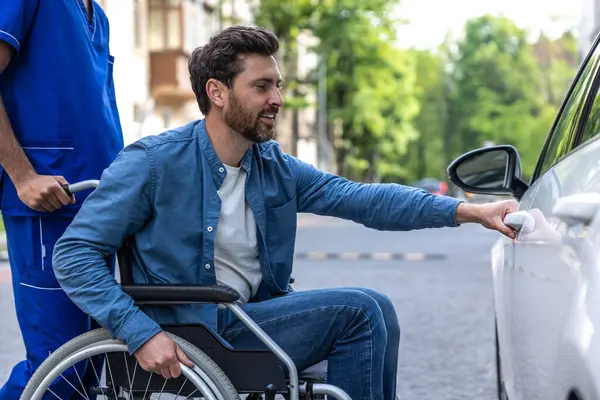 Car for disabled man. Man in a wheelchair opening a car door