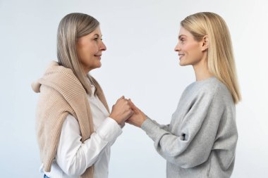 Yakınlık. Anne ve kızı el ele tutuşuyorlar.