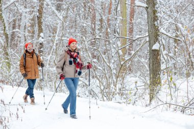 Boş zaman ve aktif dinlenme. Kış ormanında yürüyüş yapan ve mutlu görünen bir çift.