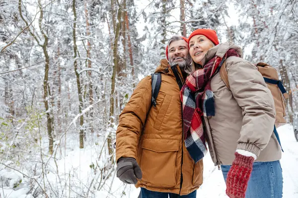 Winter mystery. Man and woman in warm clothes spending time in a winter forest